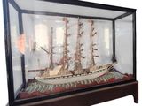 a glass case with a model of a ship in it