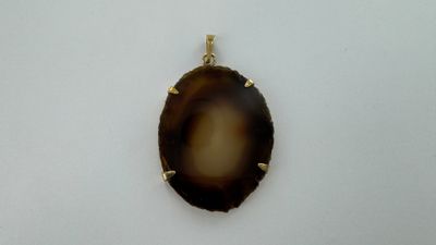 une photo d'une photo d'un pendentif posé sur une surface blanche
