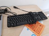 a keyboard and a mouse on a desk with a laptop