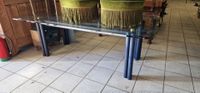Importante table moderne dessus verre piètement métallique.