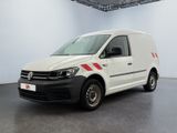 La camionnette blanche est garée dans une grande pièce au sol noir.