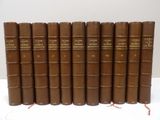 six brown books are lined up on a white surface