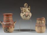 trois vases décorés de motifs sont posés sur un socle