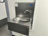 a stainless steel sink with a faucet in the corner