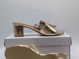 the gold shoe is sitting on top of a white box