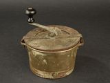 an old metal pot with a wooden handle on a table