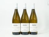 trois bouteilles de vin posées sur une table blanche