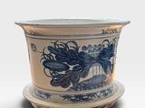 a blue and white flower pot with a saucer on it