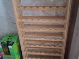 a wooden wine rack with bottles on it in a room