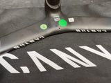 a close up of a black and white t - shirt with a green sticker on it