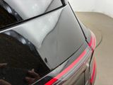 a black car with a red stripe parked in a parking lot