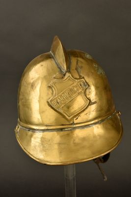 un casque ancien en laiton surmonté d'un bouclier