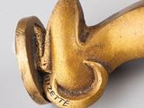 a close up of a gold colored object on a white surface