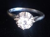 gros plan d'une bague en diamant sur une surface noire
