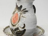 un vase blanc et une soucoupe ornés d'une fleur