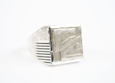 an image of a close up of a silver ring on a white surface