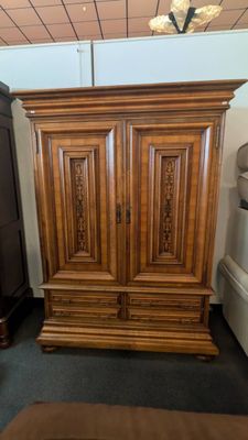 a large wooden armoire in the corner of a room