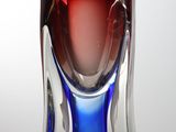 un vase en verre bleu et rouge posé sur une table