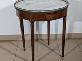 a small table with a marble top on a tiled floor