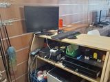 a desk with a computer on it in the corner of a room