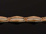 a close up of a gold bracelet on a black surface