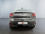 the rear end of a silver car in a white room
