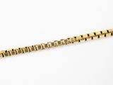 gros plan d'une chaîne en or sur une surface blanche