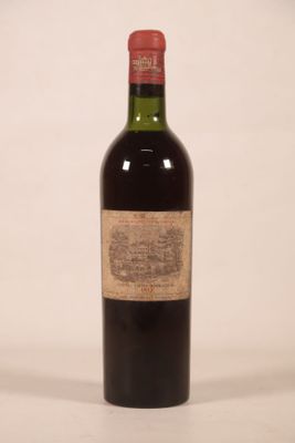 une vieille bouteille de vin posée sur une table blanche