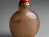 a small glass bottle with a red cap on it