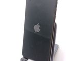 a black apple phone sitting on a stand on a white surface