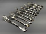 six forks are lined up in a row on a table