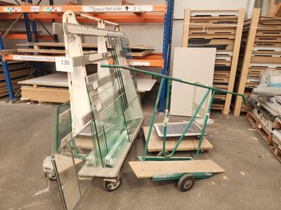 Plusieurs morceaux de verre sont empilés sur un chariot dans un entrepôt