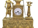 une horloge en or surmontée d'une statue