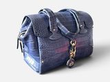 sac à main à carreaux violets et bleus sur fond blanc, avec des découpes
