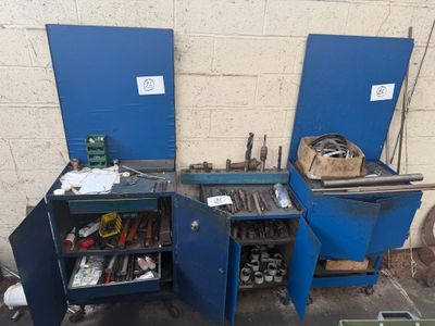 two blue cabinets with tools in them in a garage