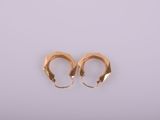 a pair of gold hoop earrings on a white background