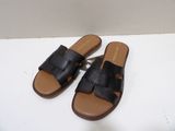 black leather sandals on a white surface with a white background