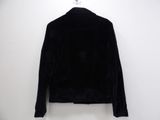 black velvet jacket hanging on a white hanger on a wall