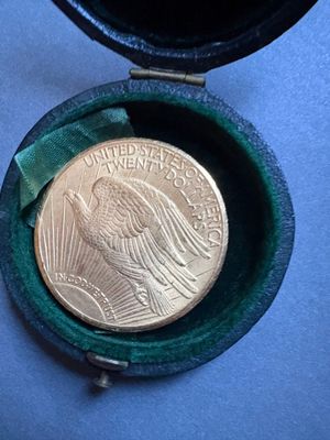 une pièce d'or dans un étui vert posé sur un fond bleu