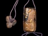 a small wooden object with a rope on a black background