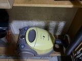 un aspirateur posé sur le sol à côté d'une boîte
