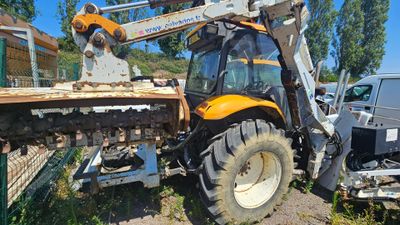 a tractor that is sitting in the dirt near a truck