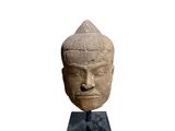 an image of a stone head of a person on a stand
