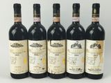 quatre bouteilles de vin sont alignées sur une surface blanche