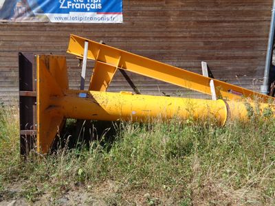 un tracteur qui est garé dans l'herbe près d'un bâtiment