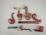 many different types of smoking pipes and pipes on the table