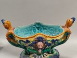 un saladier bleu et vert posé sur une table blanche