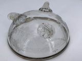 a glass lid with a bird on it on a white table