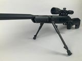 the rifle is sitting on a tripod on a white surface