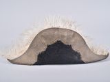 a hat with a feather on it on a white surface